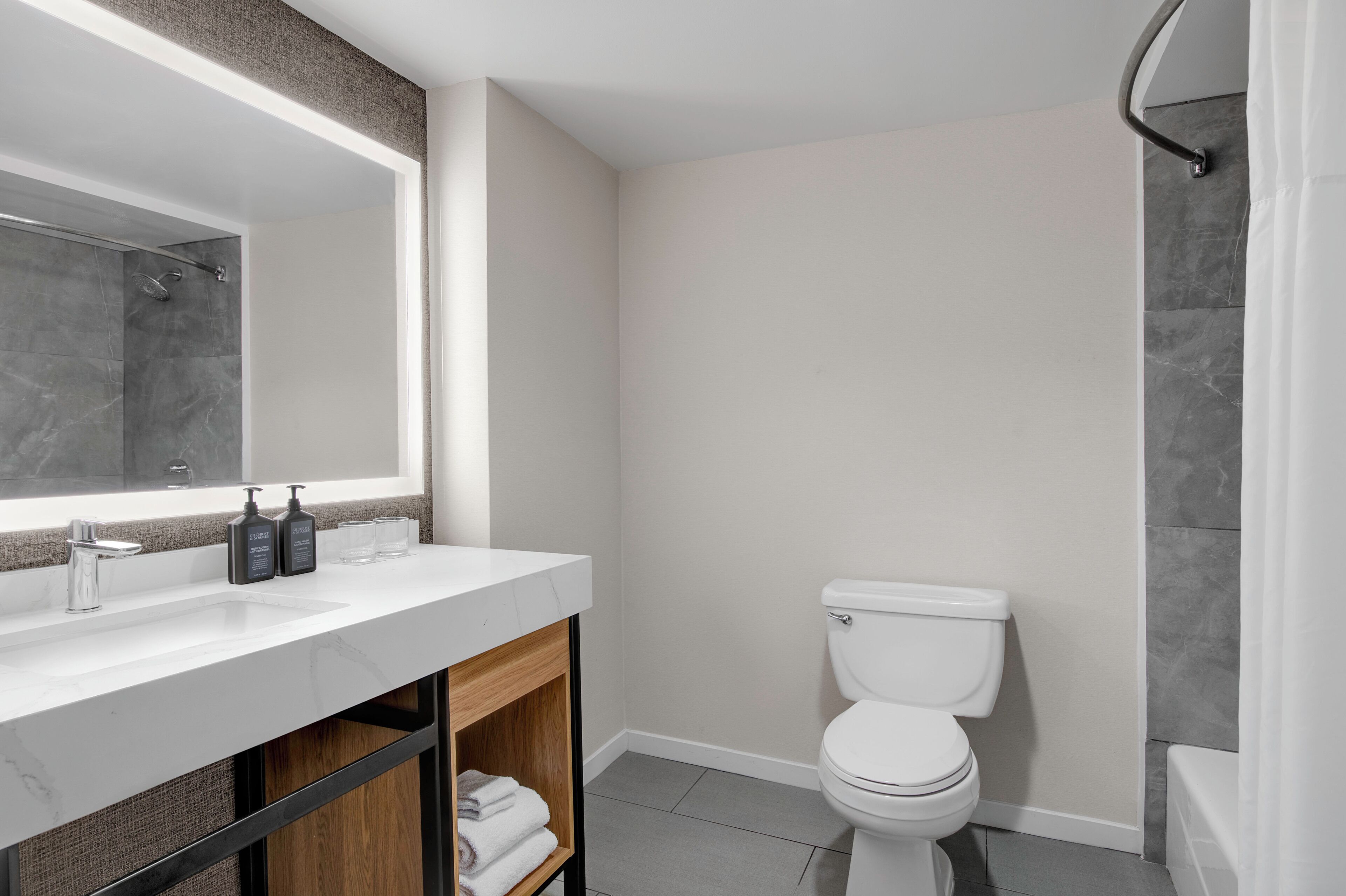 A modern bathroom with a white sink, a toilet, and a shower area.