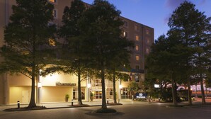 Un hotel Sheraton con una fachada moderna, varios pisos y una entrada bien iluminada.