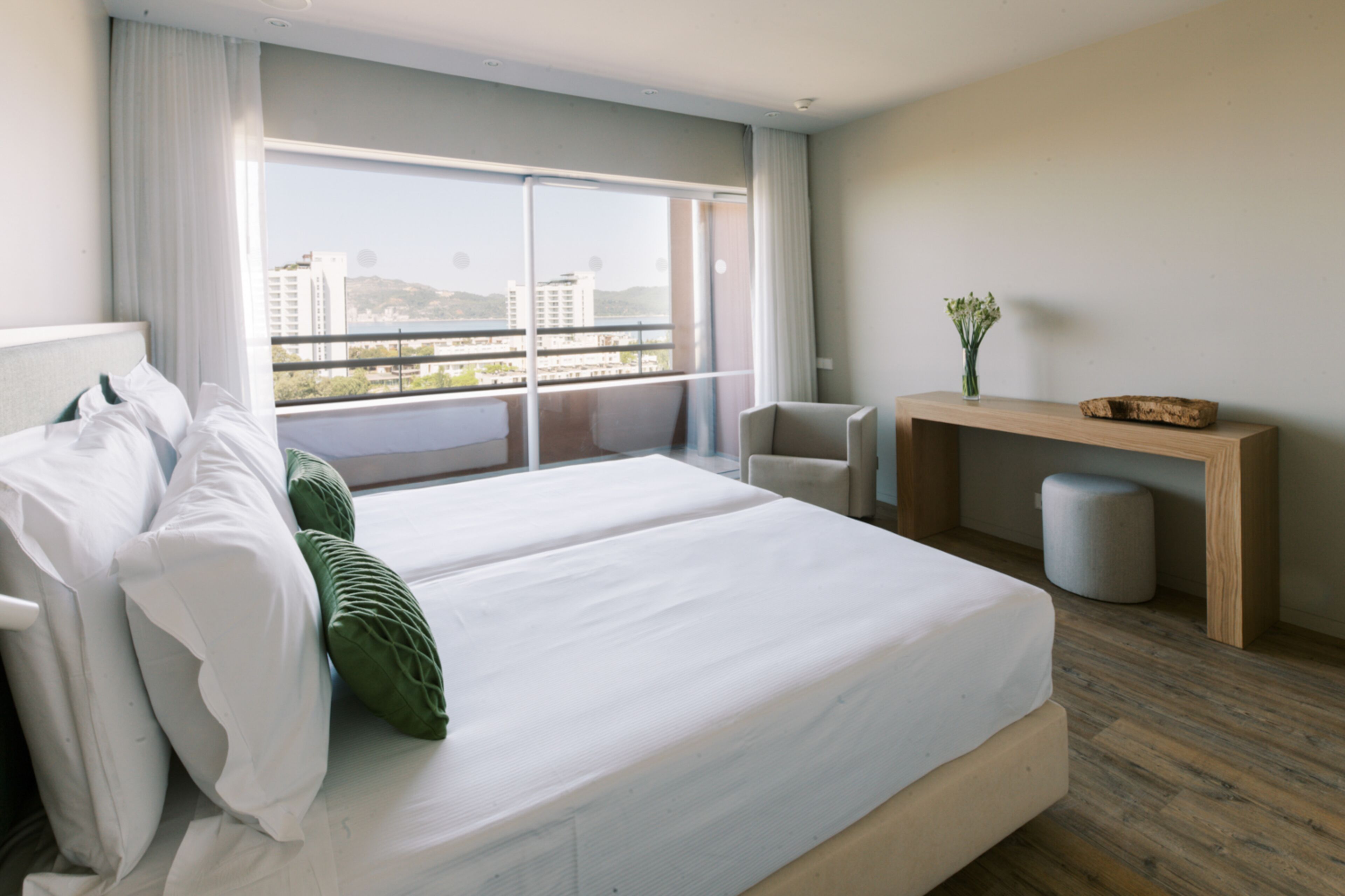 Una habitación de hotel moderna con una cama grande, un escritorio y vistas a la ciudad.