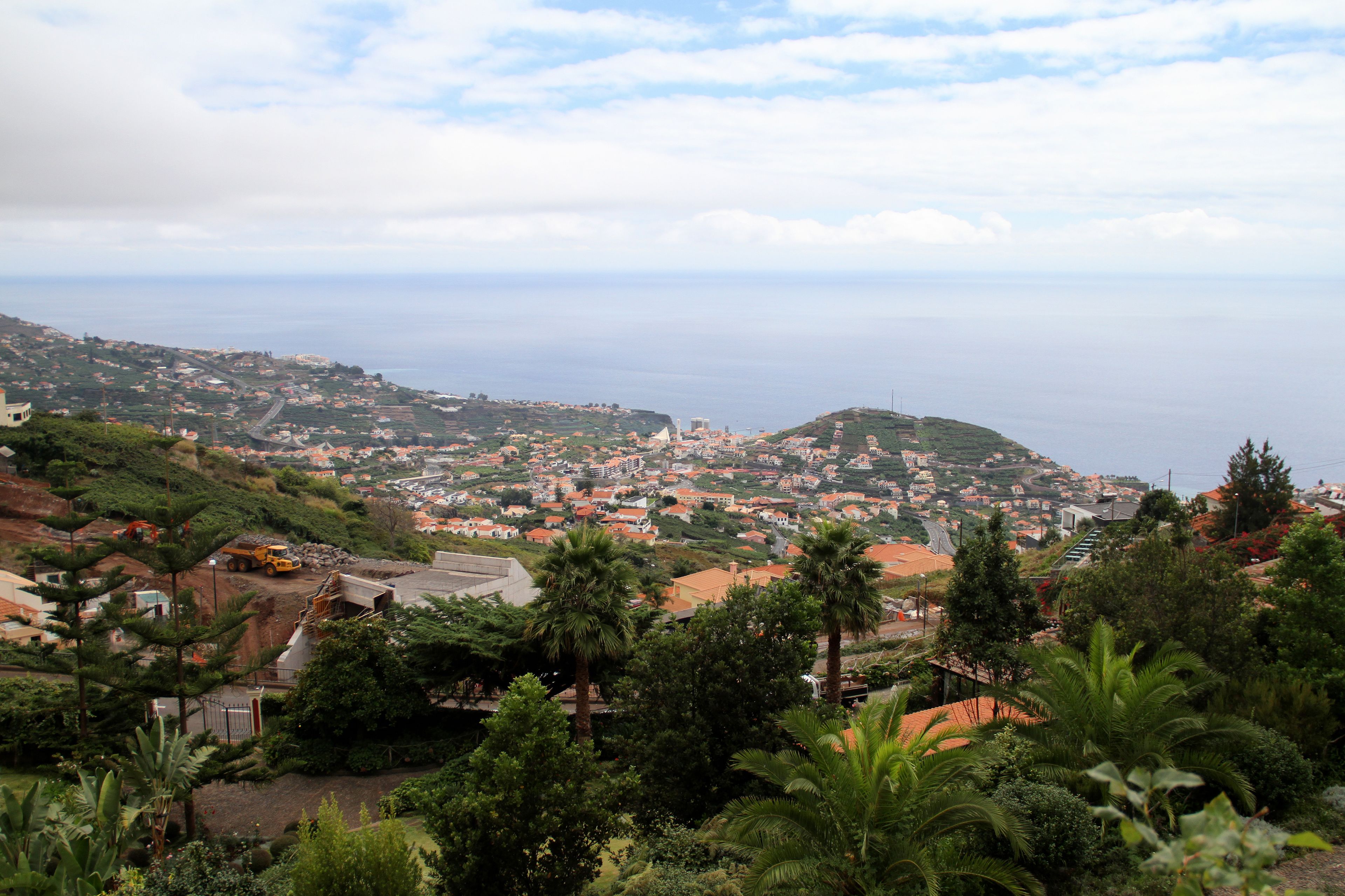 A coastal town with a mix of residential and commercial buildings, a prominent church, and a view of the sea.
