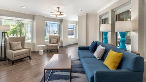 A modern living room with a sofa, armchairs, a coffee table, and a lamp. - Comfort Inn Fontana (Fontana)