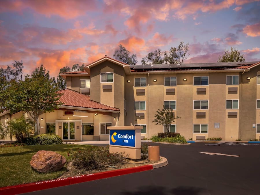 A Comfort Inn hotel with a red-tiled roof, multiple windows, and a signboard.