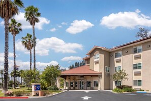 A hotel entrance with a red roof, palm trees, and a sign for Comfort Inn. - Comfort Inn Fontana (Fontana)