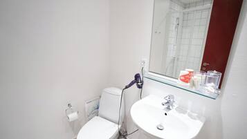 A small, modern bathroom with a toilet, sink, and a mirror above the sink.