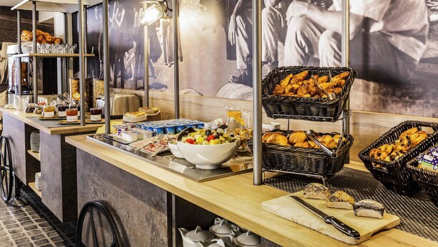 A breakfast buffet with various food items, including pastries, fruits, and beverages, arranged on a counter with a modern design. - Ibis Styles Paris Mairie de Clichy (Clichy)