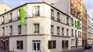 A corner building with multiple windows and balconies, featuring green signage for 'ibis styles'. - Ibis Styles Paris Mairie de Clichy (Clichy)
