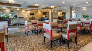 A hotel lobby with multiple seating areas, a reception desk, and a visible kitchen area. - Comfort Inn Charlotte (Charlotte)