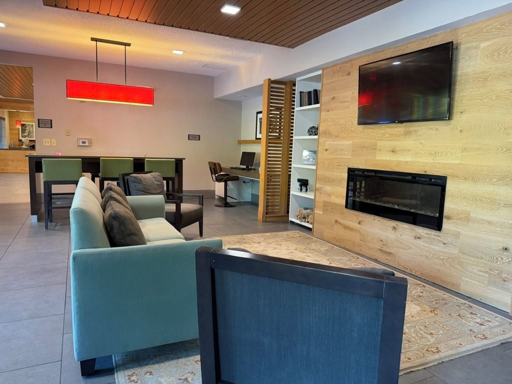 Una sala de estar moderna con sofá, chimenea, televisor y una zona de escritorio.