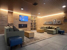 Una sala de estar moderna con una televisión de pantalla plana, sofás, una mesa de centro y una chimenea.