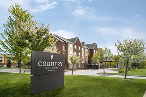 A hotel sign with 'COUNTRY INN & SUITES BY RADISSON' indicating a hotel with multiple stories, brick exterior, and a well-maintained lawn.
