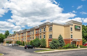A multi-story hotel with a flat roof, a covered entrance, and a sign indicating it is part of the Stay America chain.