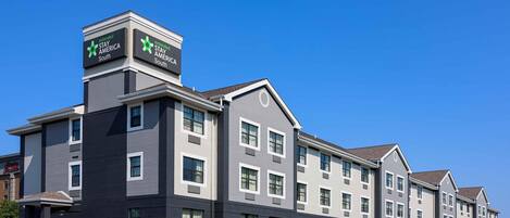 Un hotel de varios pisos con un diseño moderno, que presenta un letrero destacado de 'Extended Stay America South' en la esquina.