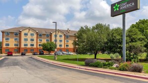 Un hotel de varios pisos con un letrero que dice Extended Stay America Suites.