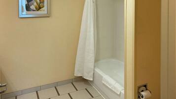 A bathroom with a bathtub, a toilet, and a shower curtain.