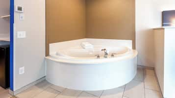 Un baño moderno con una bañera independiente, ducha integrada y un perchero para toallas.