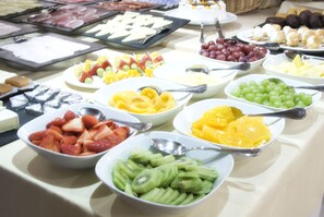 A buffet with various fruits and cheeses.