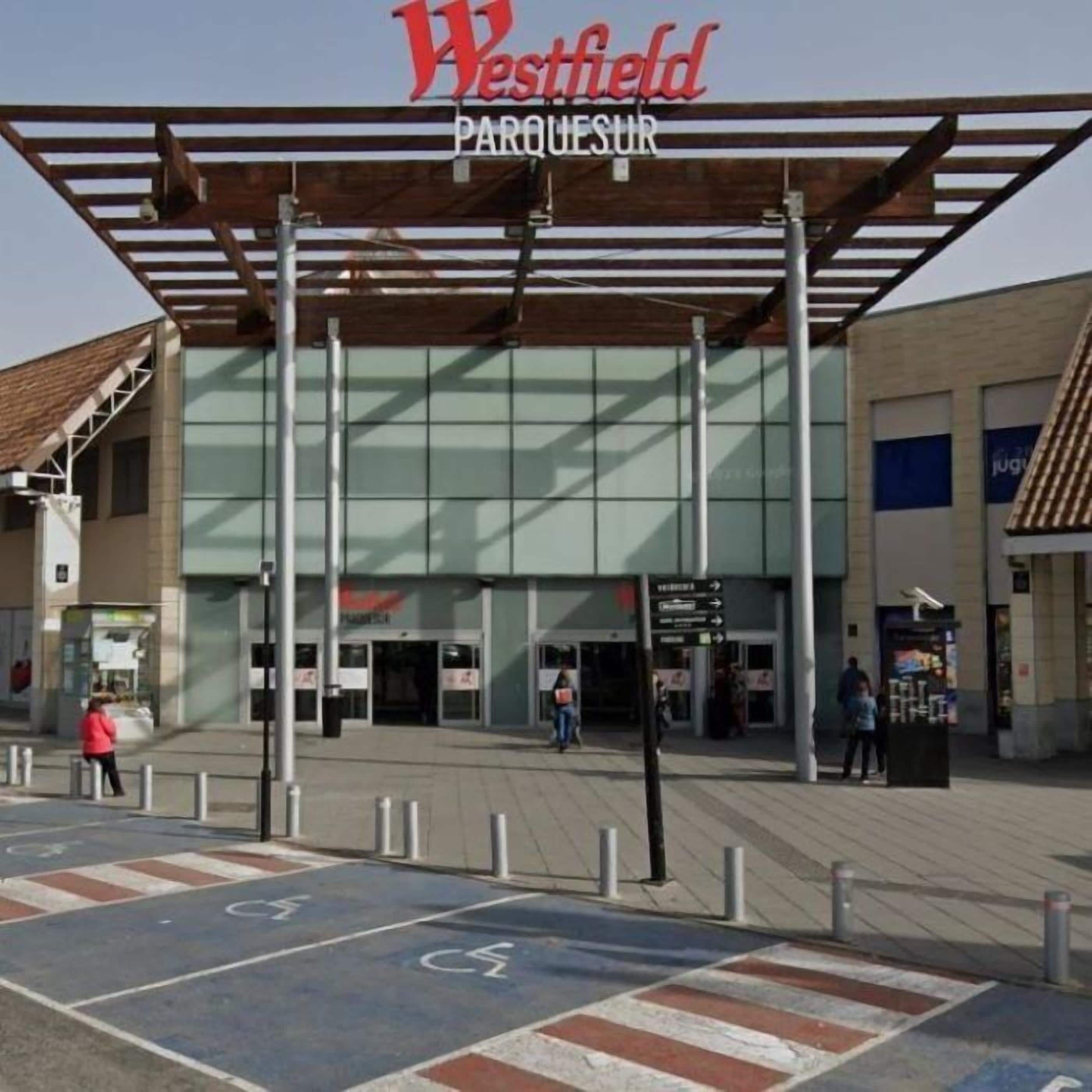 Un edificio con un cartel que dice 'Westfield PARQUE SUR' y una zona de acceso cubierta.