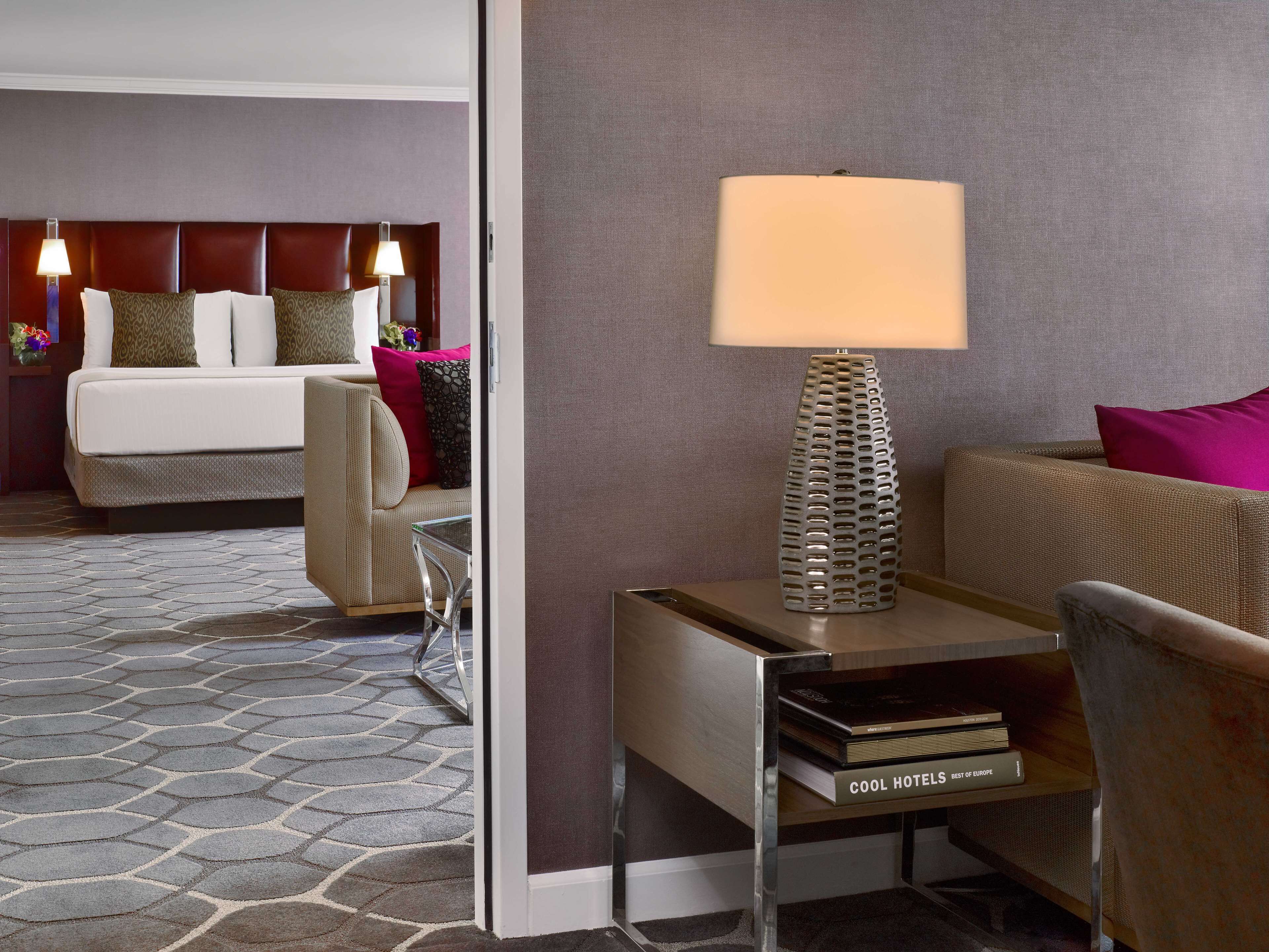 Una habitación de hotel con una cama, un sofá, una lámpara y una mesita de noche con un libro titulado 'COOL HOTELS BEST OF EUROPE'.