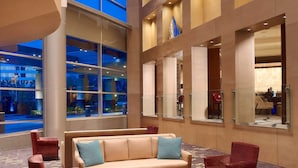 A spacious lobby with a high ceiling, large windows, and a modern interior design.