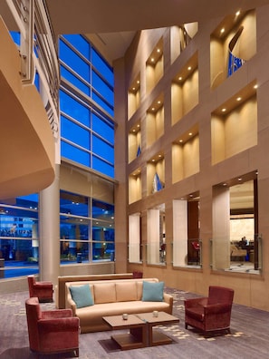A spacious lobby with a high ceiling, large windows, and a modern interior design. - The Royal Sonesta Houston Galleria (Houston)