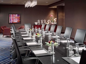 A conference room with a long table, chairs, and a chandelier.