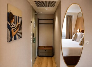 A hotel room with a bed, a bedside table, a mirror, and a painting on the wall. - De Herbert Amsterdam (Formerly France Hotel) (Amsterdam)