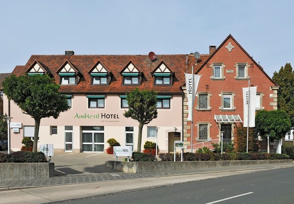 Ein Hotel im traditionellen europäischen Baustil, mit einer symmetrischen Fassade, zahlreichen Fenstern und einem markanten Eingang.