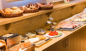 Een buffetopstelling met diverse gerechten en bestek.