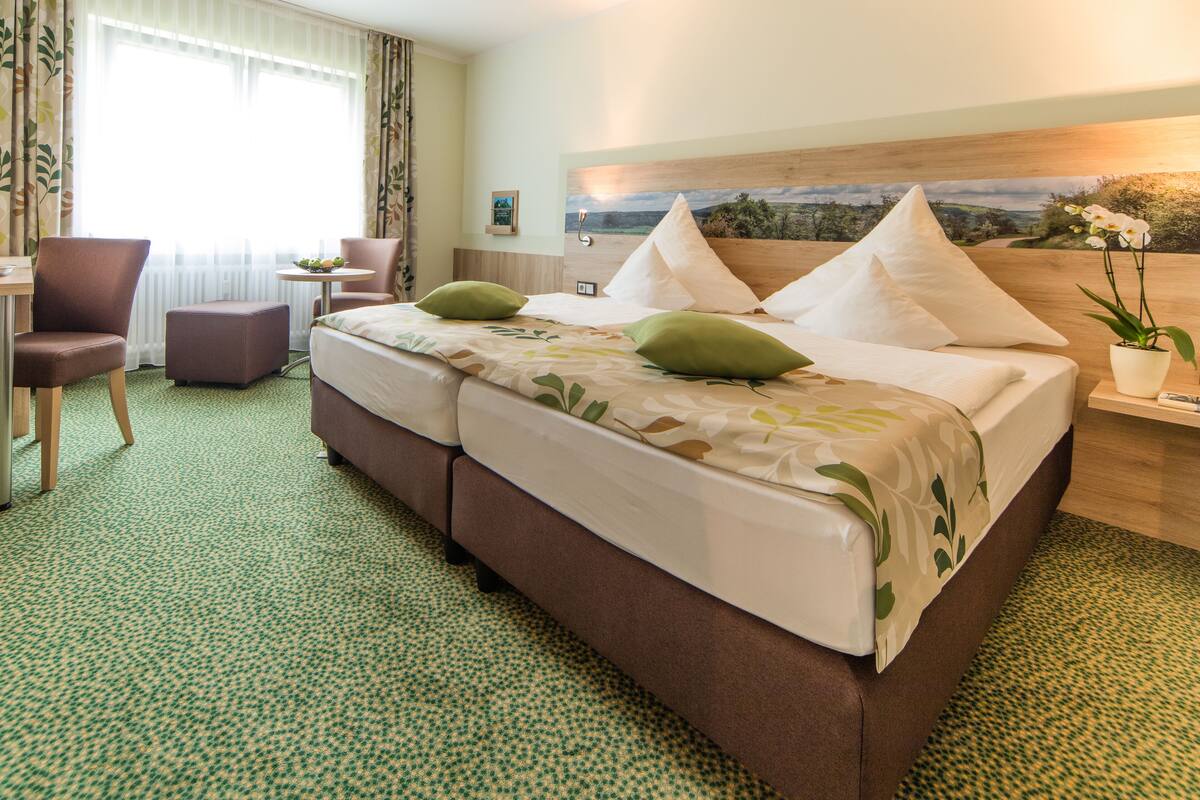 Une chambre d’hôtel avec un grand lit, un bureau, une chaise et une petite table.
