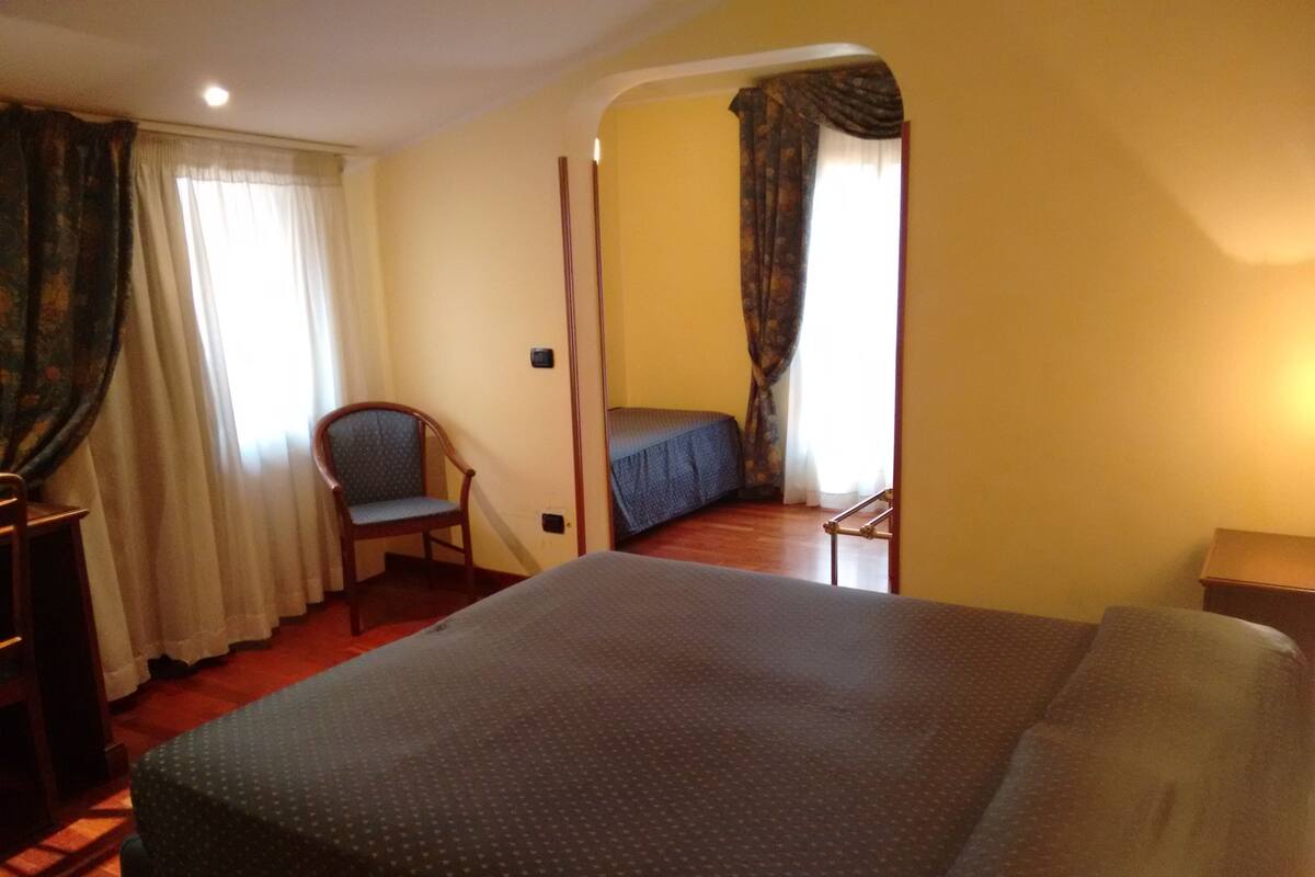 Une chambre d’hôtel avec un grand lit, une chaise, un bureau et une petite table.