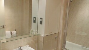 Une salle de bain moderne avec une douche à parois de verre, un lavabo blanc et des toilettes.