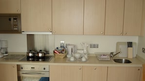 Une cuisine équipée d’un four à micro-ondes, d’une cuisinière, d’un four, d’un évier et de divers ustensiles de cuisine.