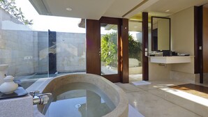 Uma casa de banho moderna com uma banheira grande, uma pia e um espelho.