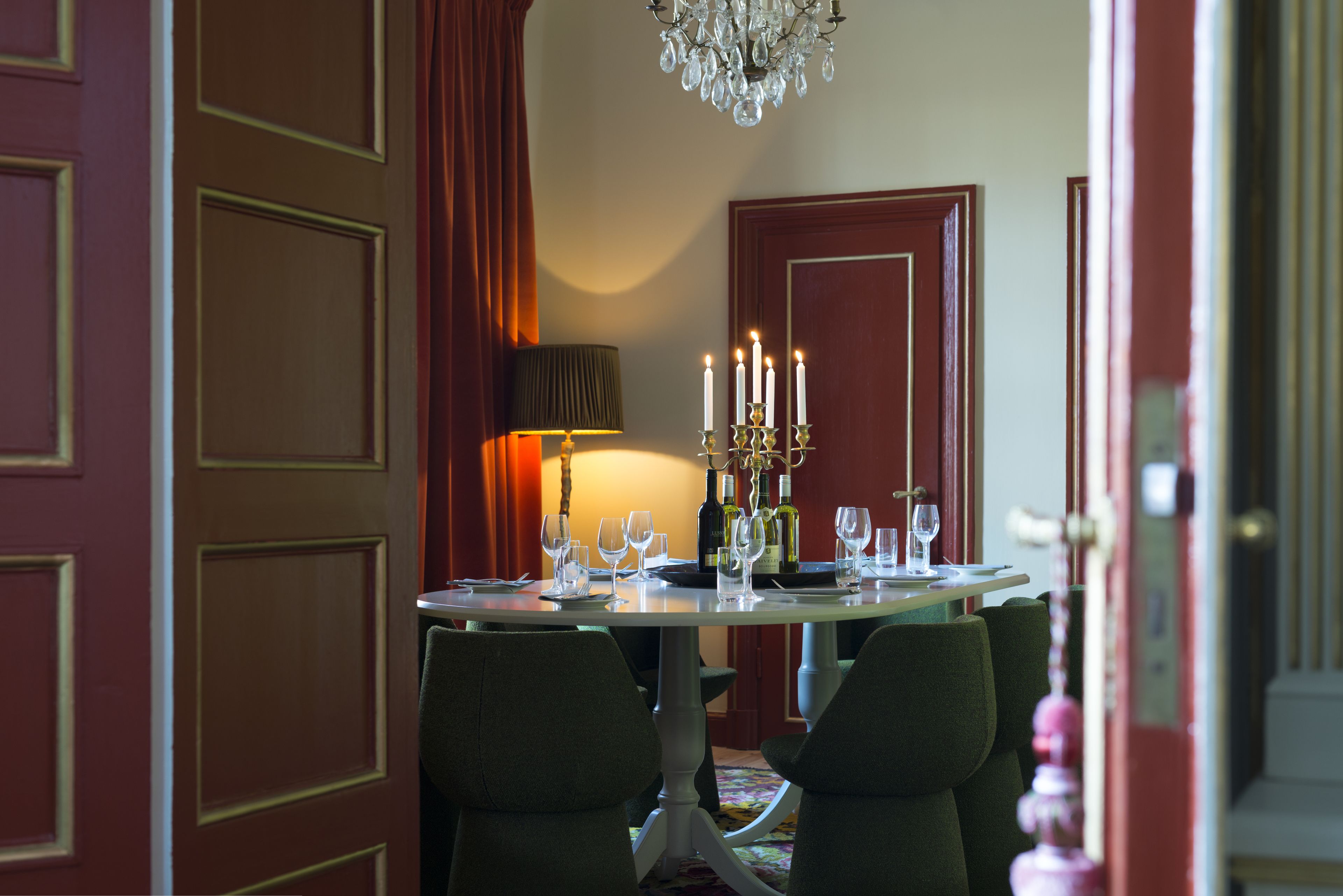 A dining area with a round table set for four, surrounded by chairs.