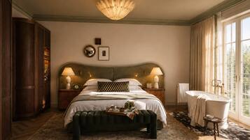 A bedroom with a large bed, two bedside lamps, a wooden wardrobe, a round mirror, and a window with curtains.