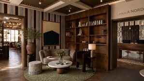 A cozy interior with a sofa, a round coffee table, and a bookshelf filled with books and decorative items. - Villa Nord (Trondheim)