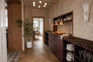 Eine Küche mit Holzausstattung, einem Blumentopf und einem Essbereich im Hintergrund.