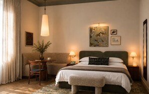 A hotel room with a bed, bedside tables, a desk with a chair, a vase with flowers, and artwork on the wall. - Villa Nord (Trondheim)