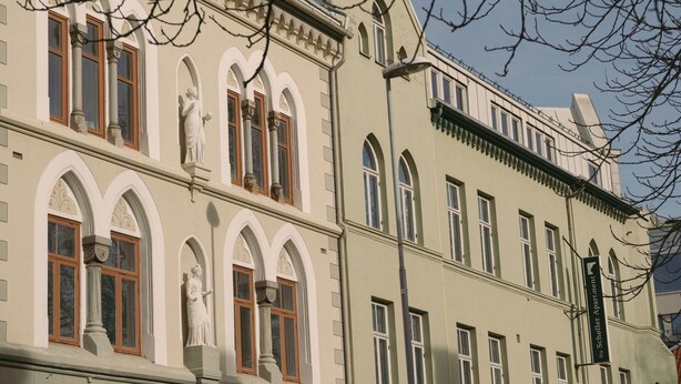 A building with arched windows, a statue, and a sign indicating 'Scholle Apartment.' - Villa Nord (Trondheim)