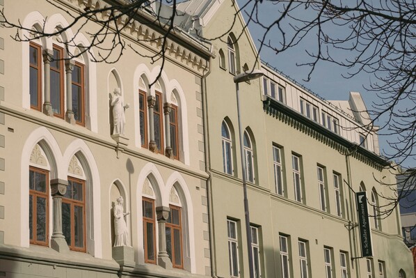 A building with arched windows, a statue, and a sign indicating 'Scholle Apartment.' - Villa Nord (Trondheim)