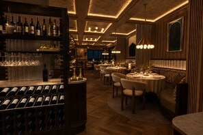 A restaurant interior with a bar area, multiple dining tables, and a cozy seating arrangement. - Villa Nord (Trondheim)