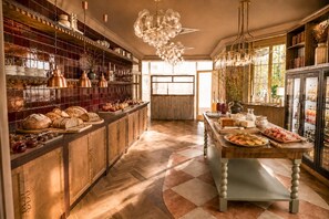A spacious kitchen with wooden cabinets, a central island, and a variety of food items displayed on shelves and counters.