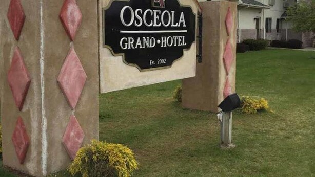 The entrance sign of the Osceola Grand Hotel with a date of establishment (2002) and a logo. - Osceola Grand Hotel (Evart)