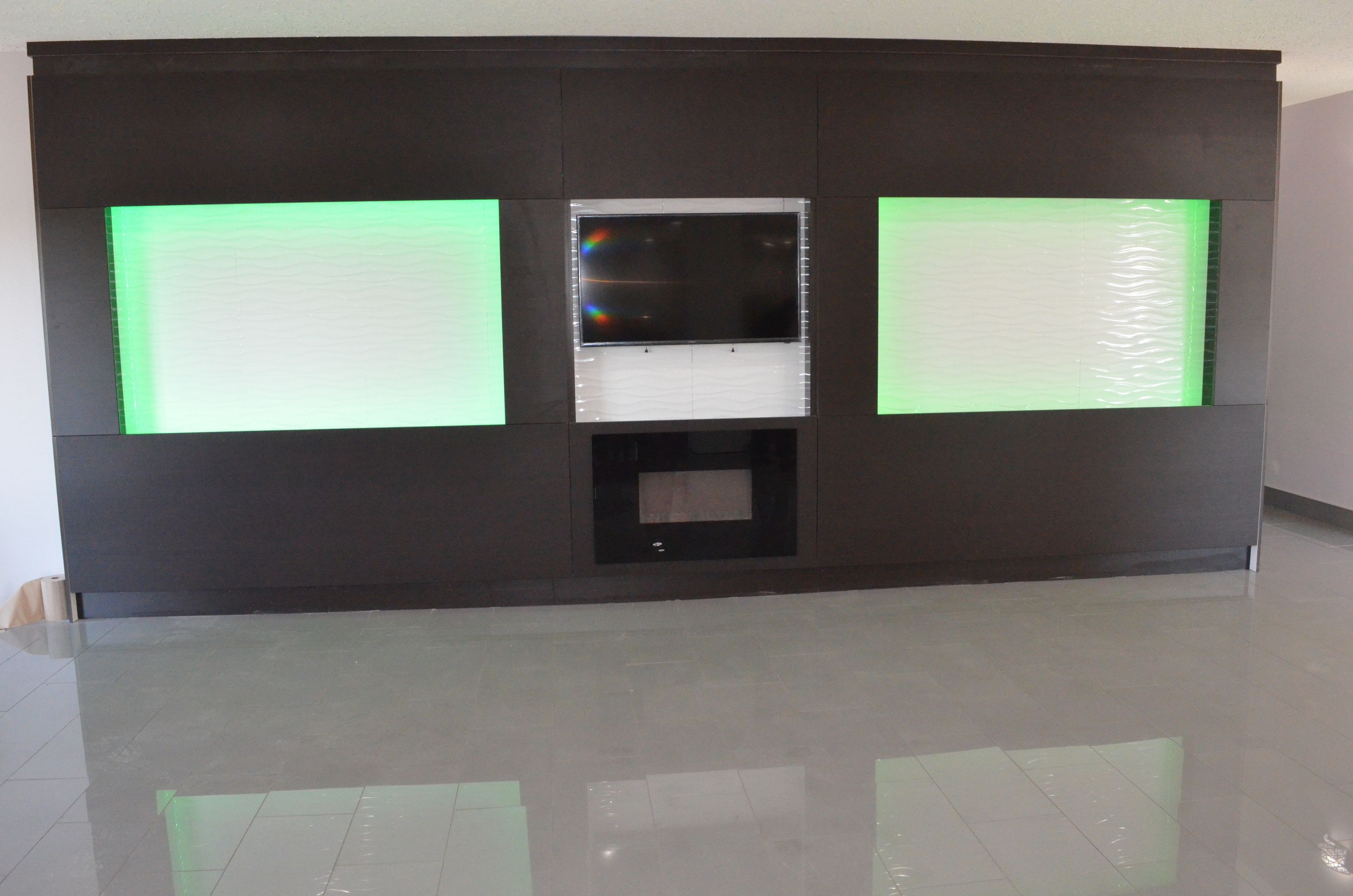 A modern hotel lobby with a large, dark-colored reception desk and a glass partition.