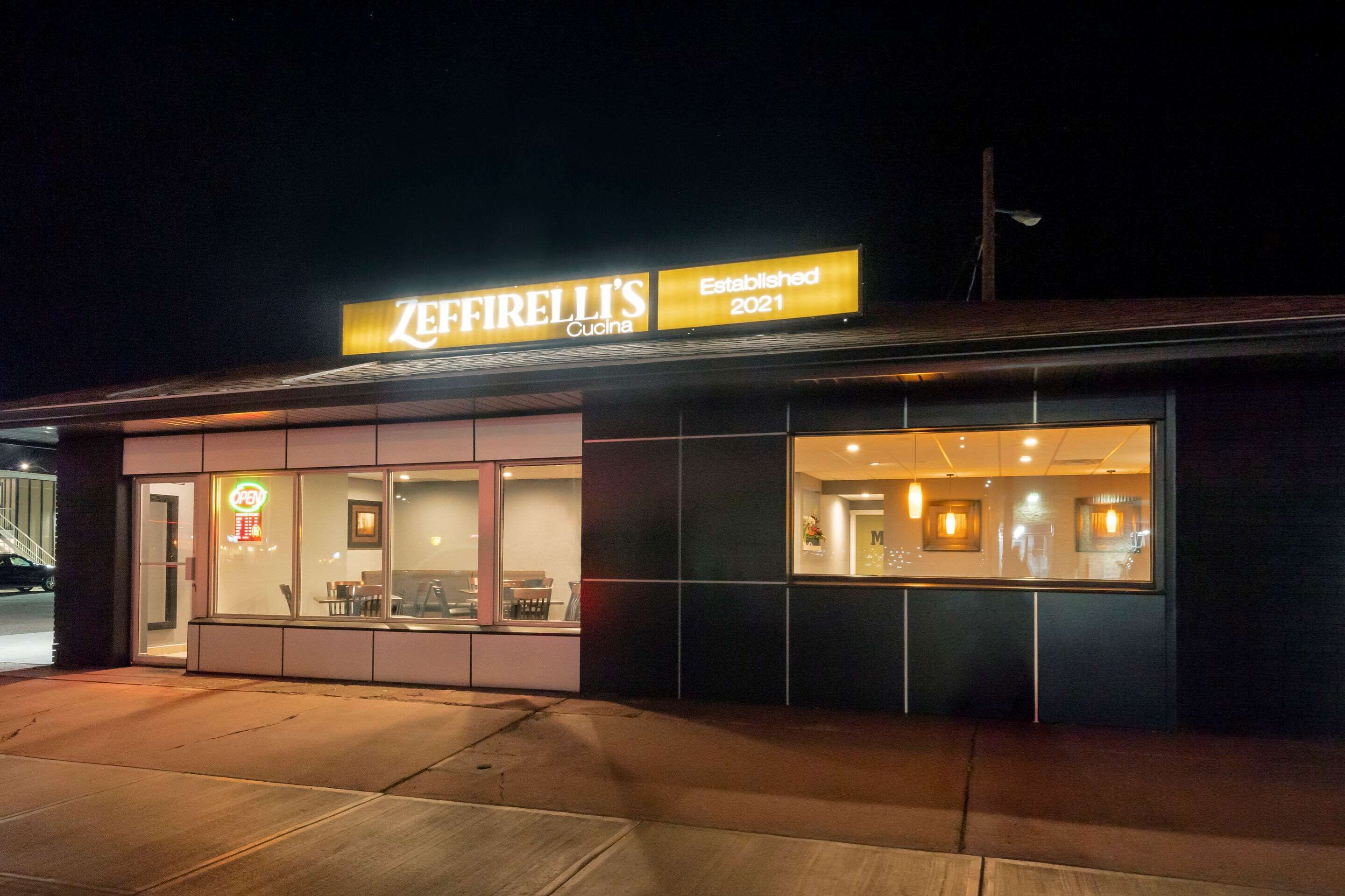 Ein Restaurant namens 'Zeffirelli's Cocina' mit leuchtendem Neon-Schild, einer Glasfassade und einem modernen Äußeren.