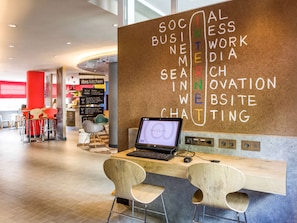 Collaborative workspace with a corkboard, desk, and seating area.