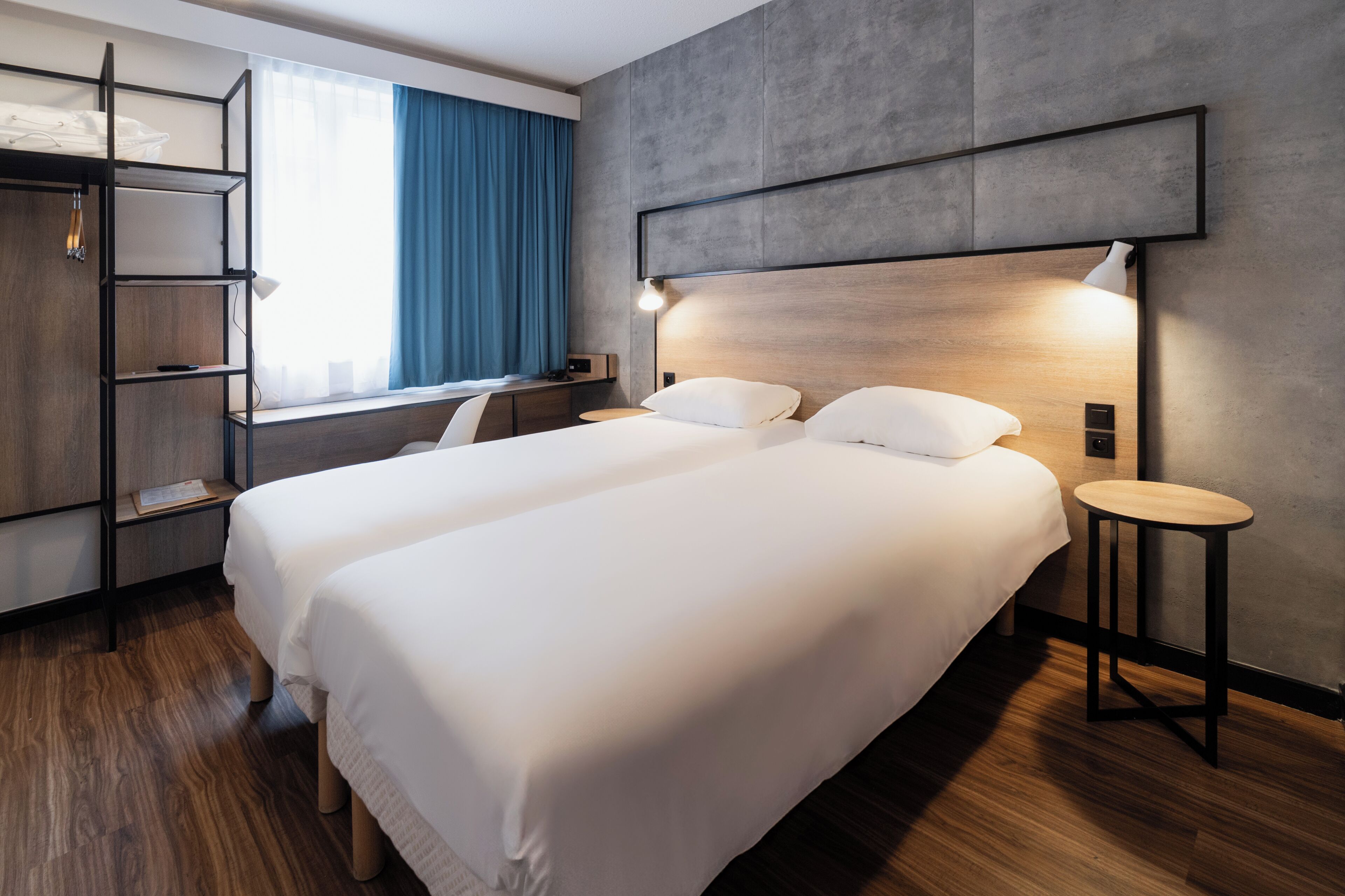 Una habitación de hotel moderna con una cama grande, un escritorio y una estantería.