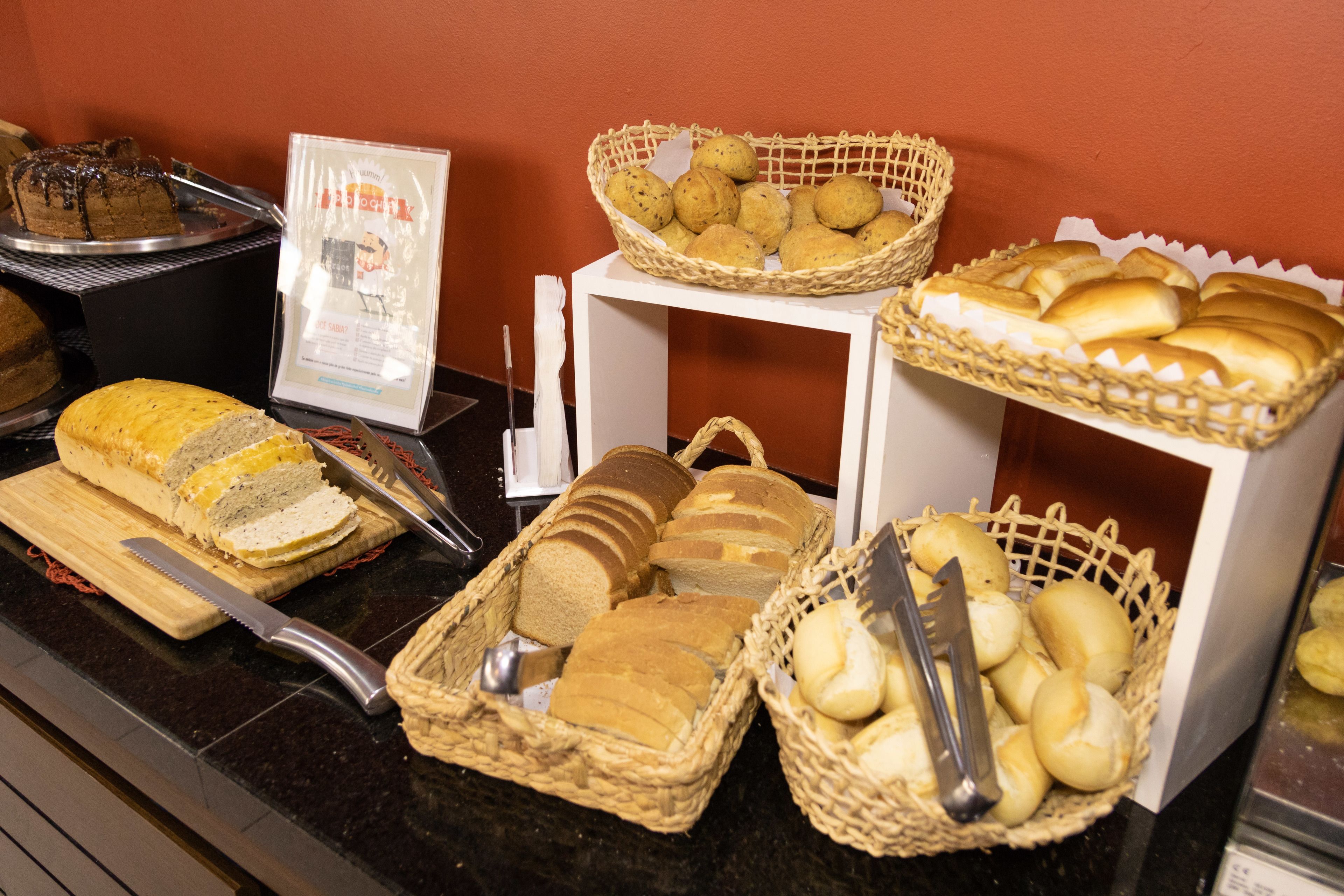 A buffet with various breads and pastries displayed in baskets.