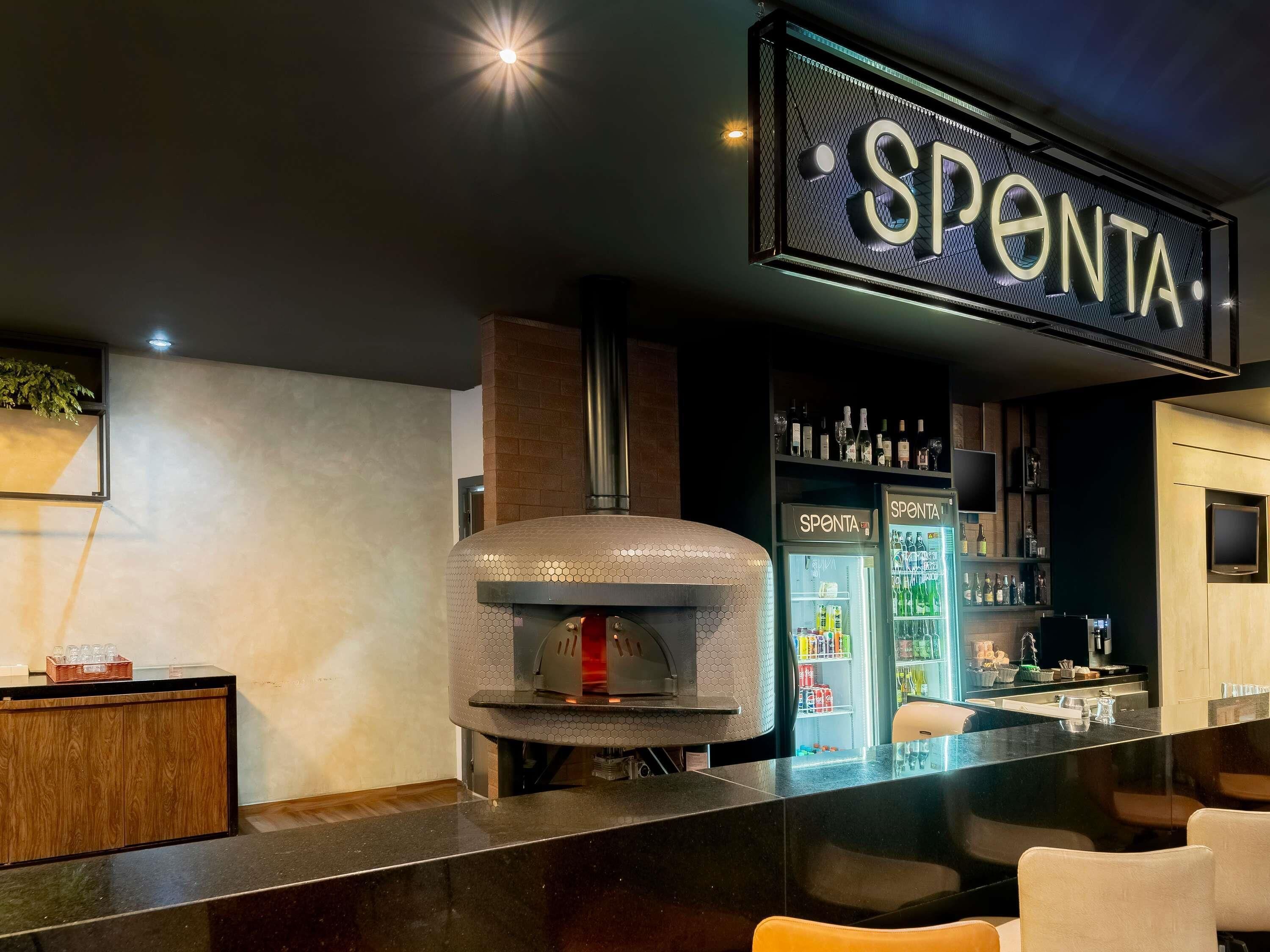 Een moderne barruimte met een pizzaoven, een Sponta koelkast en een houten toonbank.
