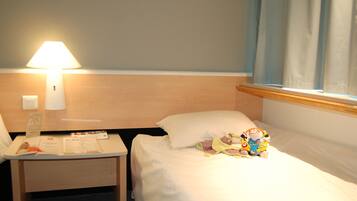 Cozy retreat with a single bed, nightstand, and table, perfect for a relaxing stay.